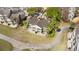 Aerial view of a yellow home featuring a patio, a well-manicured lawn, and a winding driveway at 7512 Seven Eagles Way # 7512, Reunion, FL 34747