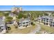 Aerial view of a yellow home with balconies, lush landscaping, a paved driveway, and community features at 7512 Seven Eagles Way # 7512, Reunion, FL 34747