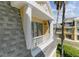 Charming balcony of a yellow home featuring white railings, overlooking mature landscaping with tall palm trees at 7512 Seven Eagles Way # 7512, Reunion, FL 34747