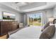 Cozy bedroom featuring a plush bed, wooden dresser, and sliding doors offering a view of the green landscaped property at 7512 Seven Eagles Way # 7512, Reunion, FL 34747