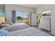 Bright bedroom featuring two beds, large window with golf course view, and a white dresser with mounted TV at 7512 Seven Eagles Way # 7512, Reunion, FL 34747