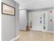 Bright foyer featuring neutral tile flooring, a white front door, and gray walls complemented by a decorative painting and storage at 7512 Seven Eagles Way # 7512, Reunion, FL 34747