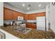 Kitchen featuring granite counters, light wood cabinets and white appliances at 7512 Seven Eagles Way # 7512, Reunion, FL 34747