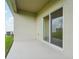 View of a patio featuring a sliding glass door and painted concrete flooring that flows from the interior at 913 Pearlwood Loop, Eagle Lake, FL 33839