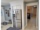 Open-concept entryway showcasing stainless steel refrigerator, tile flooring, and passageway to living room at 932 Pelican Bay Dr, Daytona Beach, FL 32119