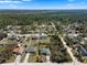 An aerial view of a quiet neighborhood surrounded by lush forest and clear blue skies at 1139 9Th Ave, Deland, FL 32724