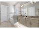 Modern bathroom with double vanity, soaking tub, marble tiling, and stylish lighting fixtures at 1148 Grand Traverse Pkwy, Reunion, FL 34747