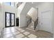 Bright foyer with a grand staircase and a decorative tile floor design at 1148 Grand Traverse Pkwy, Reunion, FL 34747