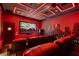 A vibrant home theater features custom lighting, comfortable leather seating, and a modern screen at 1148 Grand Traverse Pkwy, Reunion, FL 34747