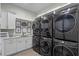 Spacious laundry room with stacked washer/dryer units, sink, and ample counter space at 1148 Grand Traverse Pkwy, Reunion, FL 34747
