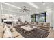 Open concept living room with access to a modern kitchen and expansive windows at 1148 Grand Traverse Pkwy, Reunion, FL 34747