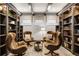 Cozy living room with custom bookshelves, wood beams, four chairs, and a small table at 1148 Grand Traverse Pkwy, Reunion, FL 34747