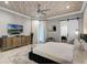 Stylish main bedroom showcasing a decorative ceiling, modern furnishings, and a sliding barn door at 1148 Grand Traverse Pkwy, Reunion, FL 34747