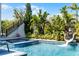 Swimming pool with a fun slide, perfect for backyard entertainment with tropical plants around pool at 1148 Grand Traverse Pkwy, Reunion, FL 34747