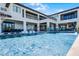 Spacious pool area with a volleyball net, patio seating, and manicured landscaping, great for outdoor activities at 1148 Grand Traverse Pkwy, Reunion, FL 34747
