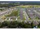 An aerial view shows this neighborhood with several homes surrounding a pond in a green landscape at 1150 August Sky Dr, Deltona, FL 32738