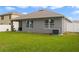 A charming backyard with a gray house, green lawn, white fence, and an air conditioning unit at 1150 August Sky Dr, Deltona, FL 32738