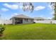 Spacious backyard with lush green grass, a white fence, and a covered patio area at 1150 August Sky Dr, Deltona, FL 32738