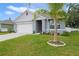 Home featuring a palm tree in the front yard, complemented by lush green grass and tasteful landscaping, creating a tropical feel at 1150 August Sky Dr, Deltona, FL 32738