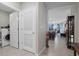 Hallway featuring tile floors, laundry room, and a view into the kitchen, creating a seamless transition between spaces at 1150 August Sky Dr, Deltona, FL 32738