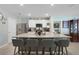 Well-lit kitchen featuring stainless steel appliances, a granite countertop island, and seating for four at 1150 August Sky Dr, Deltona, FL 32738