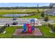 A colorful playground sits next to a green landscape, a small pond, and a parking lot at 1150 August Sky Dr, Deltona, FL 32738