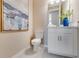 Stylish powder room with white vanity, modern fixtures, and an elegant abstract painting for a sophisticated touch at 1224 Teal Creek Dr, St Cloud, FL 34771