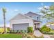 Charming two-story home with gray siding, a landscaped yard, and a welcoming red front door at 1224 Teal Creek Dr, St Cloud, FL 34771