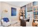 Cozy home office with stylish decor, built-in shelving, and a comfortable chair with a blue throw at 1224 Teal Creek Dr, St Cloud, FL 34771
