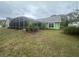 Exterior view of screened-in backyard pool and lawn at 123 Breezy Oaks Ct, Davenport, FL 33896