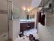 Bathroom includes vanity, sink, framed mirror, shower, and patterned tile floor at 123 Breezy Oaks Ct, Davenport, FL 33896