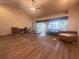 A living room boasts an open layout, wood floors, and sliding glass doors for natural light at 123 Breezy Oaks Ct, Davenport, FL 33896