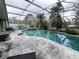 Wide angle of backyard pool with surrounding deck under screened enclosure at 123 Breezy Oaks Ct, Davenport, FL 33896