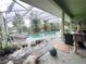 Backyard pool with surrounding deck under screened enclosure and lounge chairs at 123 Breezy Oaks Ct, Davenport, FL 33896