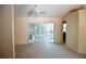 Bright living room with neutral carpet, a fan, and a sliding glass door to a patio at 12312 Woodglen Cir, Clermont, FL 34711