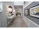 Bright hallway with gray floors, decor, and wall art leading to a living room at 1234 Sand Torch Cir, Davenport, FL 33837