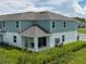 An aerial view of the rear exterior showing a covered patio and grass lawn under partly cloudy skies at 1234 Sand Torch Cir, Davenport, FL 33837