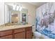 Bathroom featuring granite countertops, wood cabinets, mirror, and shower with cat shower curtain at 12862 Strode Ln, Windermere, FL 34786