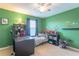 Comfortable bedroom with green walls, ceiling fan, carpeted floors, desk, and decor at 12862 Strode Ln, Windermere, FL 34786
