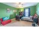 Comfortable bedroom with green walls, ceiling fan, carpeted floors, desk, and decor at 12862 Strode Ln, Windermere, FL 34786