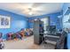 Bedroom with blue walls, carpeted floors, a ceiling fan, shelving, a desk, and decor at 12862 Strode Ln, Windermere, FL 34786