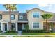 Two-story townhome showcases a landscaped front yard, mature palms, and neutral color palette at 12862 Strode Ln, Windermere, FL 34786
