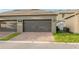 Attached two-car garage featuring brick paver driveway, adding curb appeal to the property at 12862 Strode Ln, Windermere, FL 34786