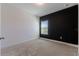 An empty bedroom features neutral carpet, a black accent wall, and natural light from the window at 14007 Picard Aly, Winter Garden, FL 34787
