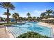 Stunning community pool area featuring lush landscaping, palm trees, lounge chairs, and a fun splash zone for children at 14007 Picard Aly, Winter Garden, FL 34787