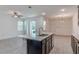 Open-concept design with modern kitchen island, dark cabinets, stainless appliances, seamlessly connecting to the living space at 14007 Picard Aly, Winter Garden, FL 34787