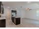 Open concept kitchen with dark cabinetry, stainless appliances, and an island, seamlessly connecting to the living space at 14007 Picard Aly, Winter Garden, FL 34787
