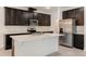 Modern kitchen featuring stainless steel appliances, dark cabinets, and white quartz countertops and island at 14007 Picard Aly, Winter Garden, FL 34787