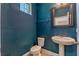 Stylish half-bathroom featuring bold blue walls and a pedestal sink at 14007 Picard Aly, Winter Garden, FL 34787