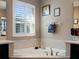 Beautiful bathroom featuring a luxurious soaking tub with travertine tile and a window for natural light at 14172 Hutchinson St, Winter Garden, FL 34787